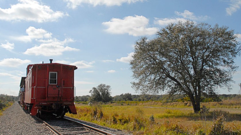 a train traveling down train tracks near a field
